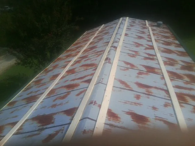 Rusted metal roof panels with new wood purlins before replacement — Storm Damage Roof Repair in Rose Hill by Roofing Brothers