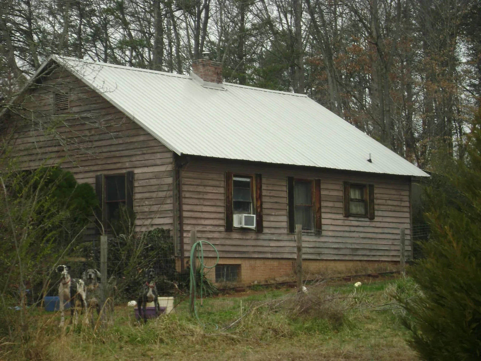 White metal roof on an old wood sided farmhouse, from a Asphalt Shingle Roof Repair job in Rose Hill